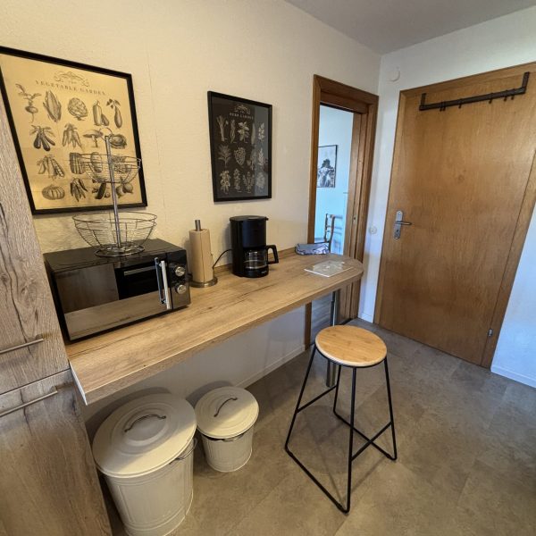 Küche mit kleiner Theke und Barhocker in der Ferienwohnung Eulennest